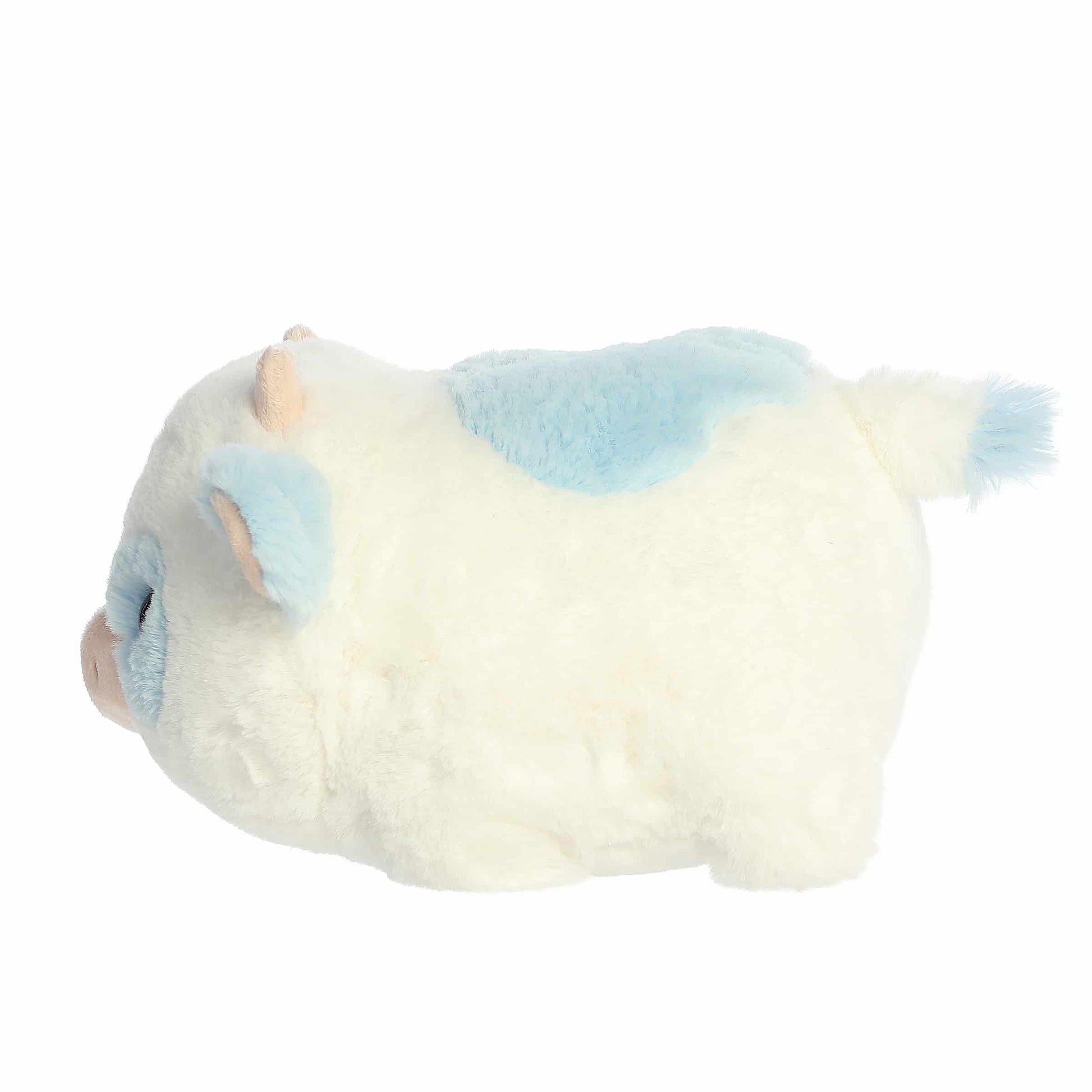 Side view of A product photo of the 10-inch Aurora Spudsters Bonnie Blueberry Cow, a white, potato-shaped plush cow with soft blue spots and a pink nose.