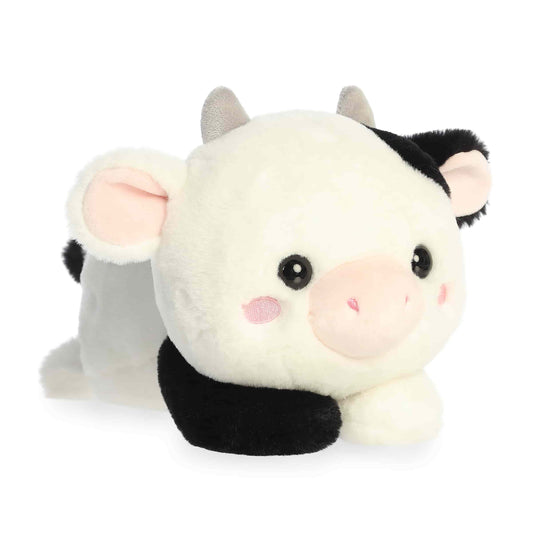 Aurora Too Cute Cayce Cow 9-inch plush soft toy, a black and white spotted cow with pink blushing cheeks and grey horns in a lay-flat pose.