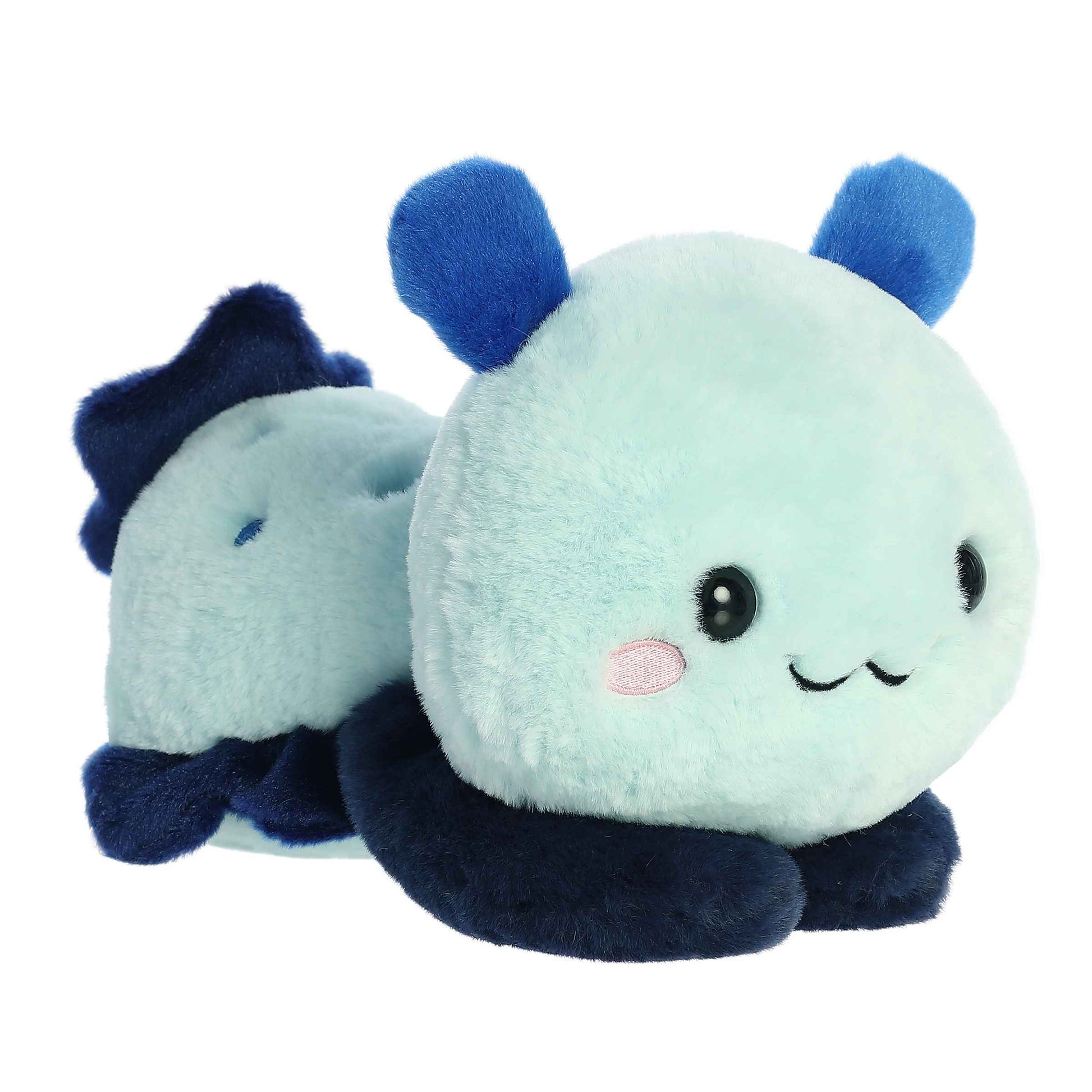 A product photo of the 9-inch Aurora Too Cute Seela Sea Slug plush, a light blue plush with dark blue fins, shown lying belly-down with its paws sprawled out on a white background.