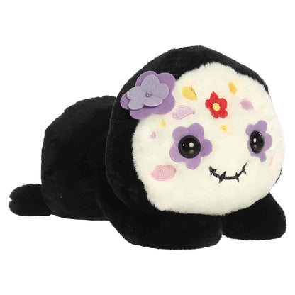 Aurora Too Cute Sissy Sugar Skull plush lying belly-down featuring a white face with colorful embroidered floral patterns and a purple 3D flower.