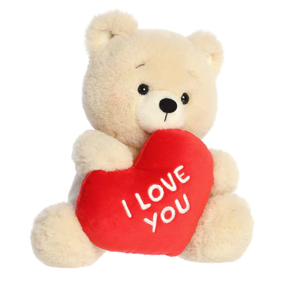 Plush teddy bear holding a red heart with 'I LOVE YOU' text on a white background