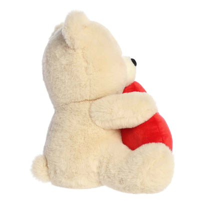 Plush bear holding a red heart on a white background