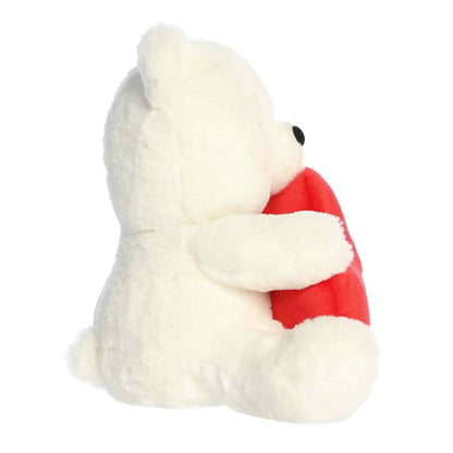 Side view of Aurora Valentine Beary Sweet Bear plush, a white teddy bear holding a red heart that says XOXO.