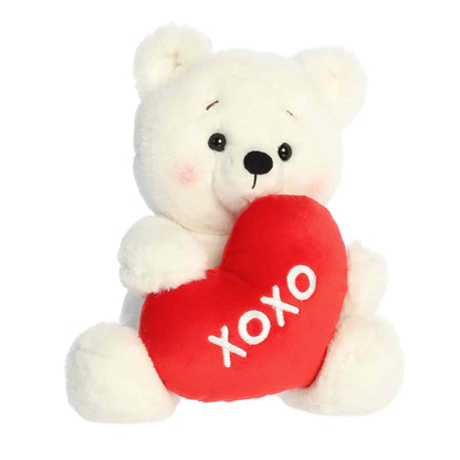 Angled view of Aurora Valentine Beary Sweet Bear plush, a white teddy bear holding a red heart that says XOXO.
