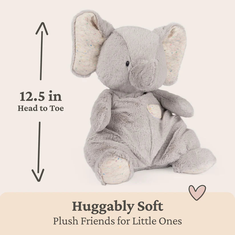 Gray plush elephant toy with measurement label and 'Huggably Soft' text on a beige background