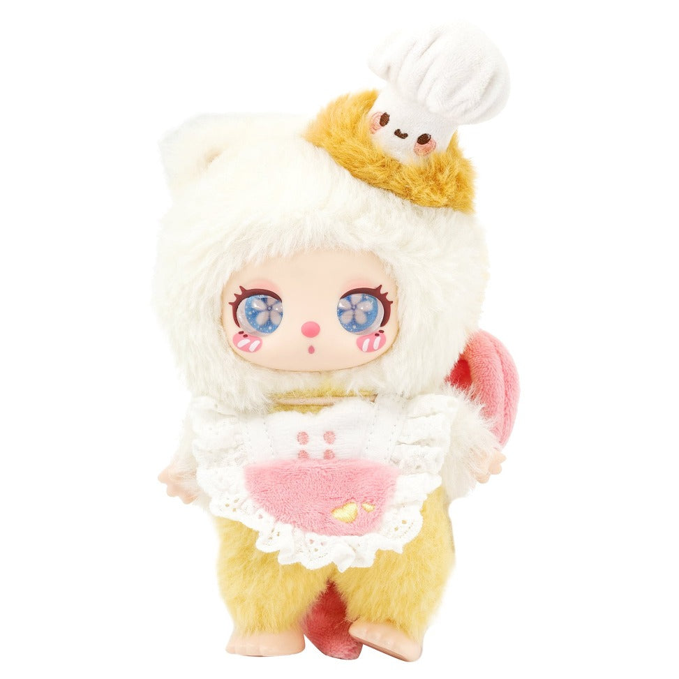 Toy figure of a character wearing a chef's outfit with a white hat and yellow apron on a white background