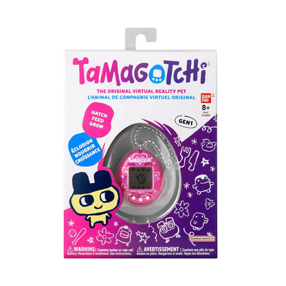Tamagotchi original virtual reality pet in its original retail packaging, featuring a pink handheld device inside a clear dome on a white, purple, and pink cardboard box.