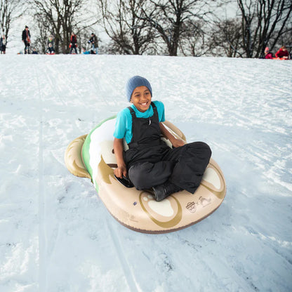 Person snow tubing down a hill on a snowy day