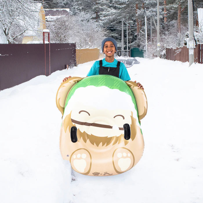 Person riding a cartoon-like snow tube in the snow