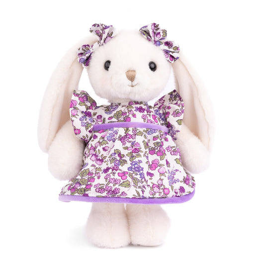 Bukowski Bears Dalia white plush bunny wearing a violet floral dress with ruffled sleeves and matching bows on her floppy ears.