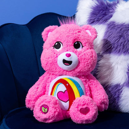 Pink teddy bear with a rainbow and heart design on a blue background