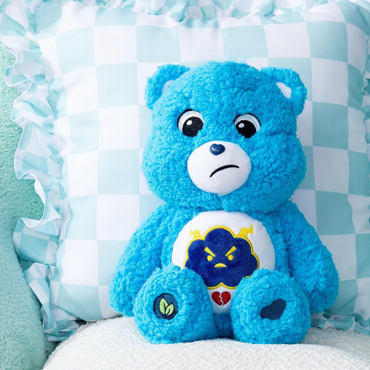 Blue teddy bear with a sad expression on a checkered background