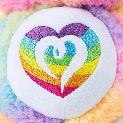 Colorful embroidered heart design on a multicolored fabric background