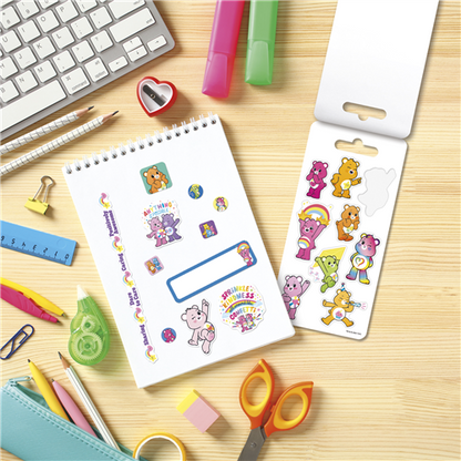 Colorful Care Bears stickers on a notebook with stationery items on a wooden surface