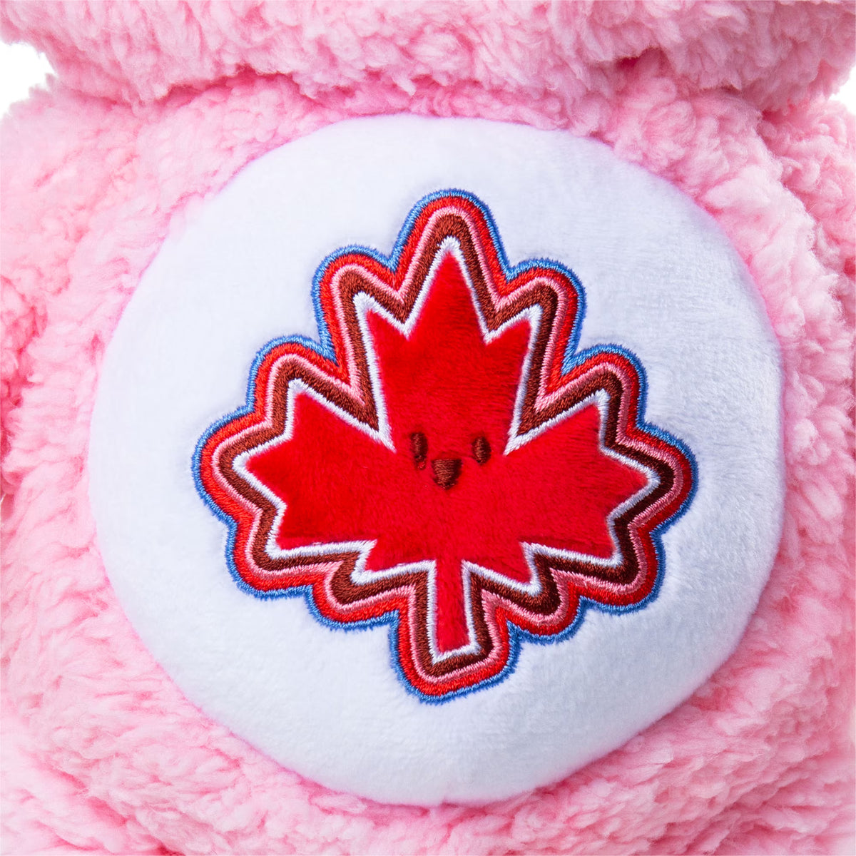 Pink plush toy with a red maple leaf design on a white background