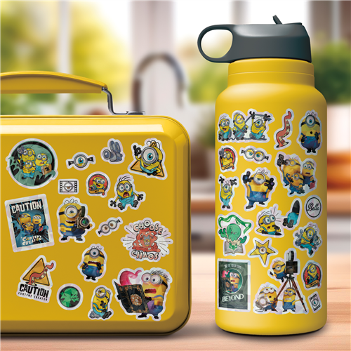 Yellow lunch box and water bottle with Minion stickers on a blurred outdoor background