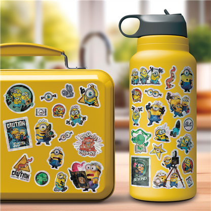 Yellow lunch box and water bottle with Minion stickers on a blurred outdoor background