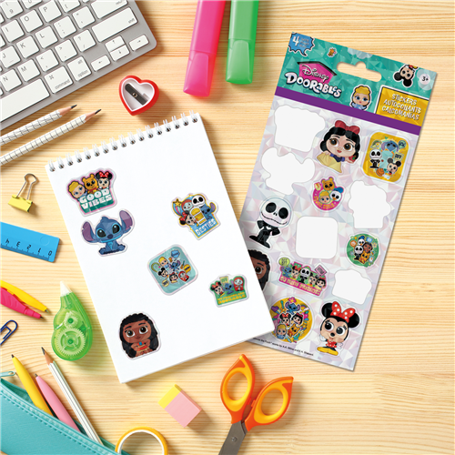 Sheet of Disney stickers with a package on a desk with stationery items