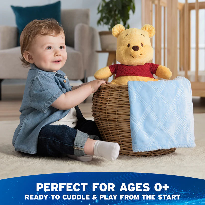 Child playing with a teddy bear in a basket, with text indicating suitability for ages 0+