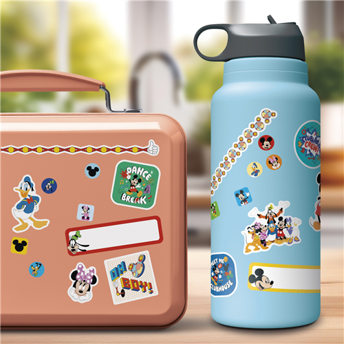 Children's lunchbox and water bottle with cartoon character stickers on a blurred outdoor background