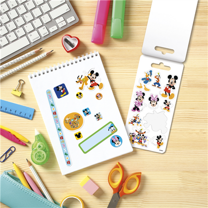 Sticker book with Mickey Mouse designs on a desk with stationery items
