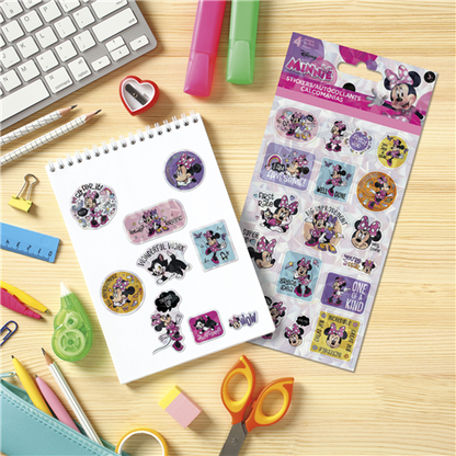Minnie Mouse-themed stickers on a notebook with stationery items on a wooden surface