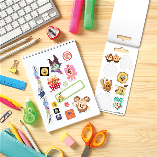 Sheet of stickers with cartoon characters on a desk with stationery items