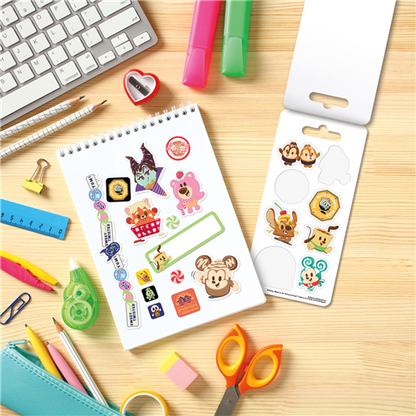 Sheet of stickers with cartoon characters on a desk with stationery items