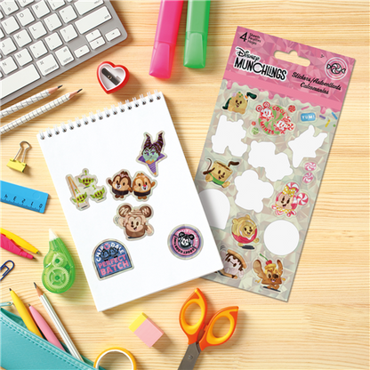 Sheet of Disney stickers on a desk with stationery items