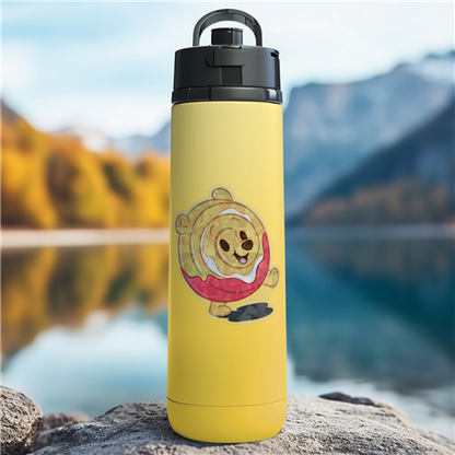 Yellow water bottle with a cartoon character on a rock by a lake with mountains in the background
