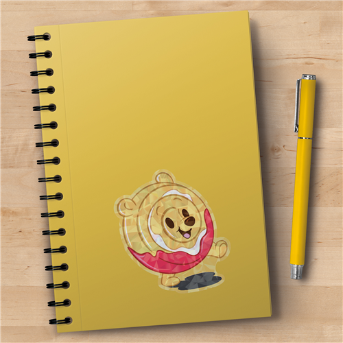 Yellow notebook with a cartoon bear design and a yellow pen on a wooden surface