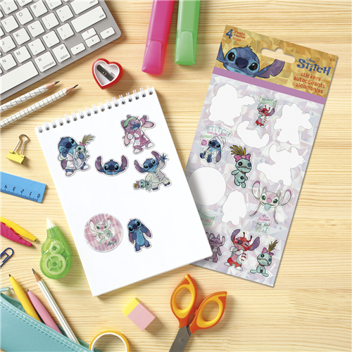 Sheet of cartoon character stickers on a notebook with stationery items on a desk.