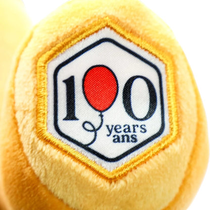 Yellow plush ball with a '100 years ans' patch featuring a red balloon.