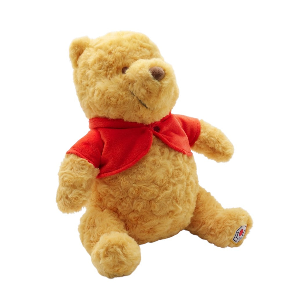 Disney Winnie the Pooh 100th Anniversary plush featuring textured rose-swirl fur and a red velvet cardigan.
