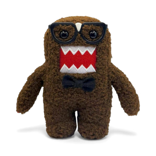 Product view of the 6.5-inch Domo plush dressed as a nerd, wearing thick black glasses with tape on the bridge and a black bow tie.