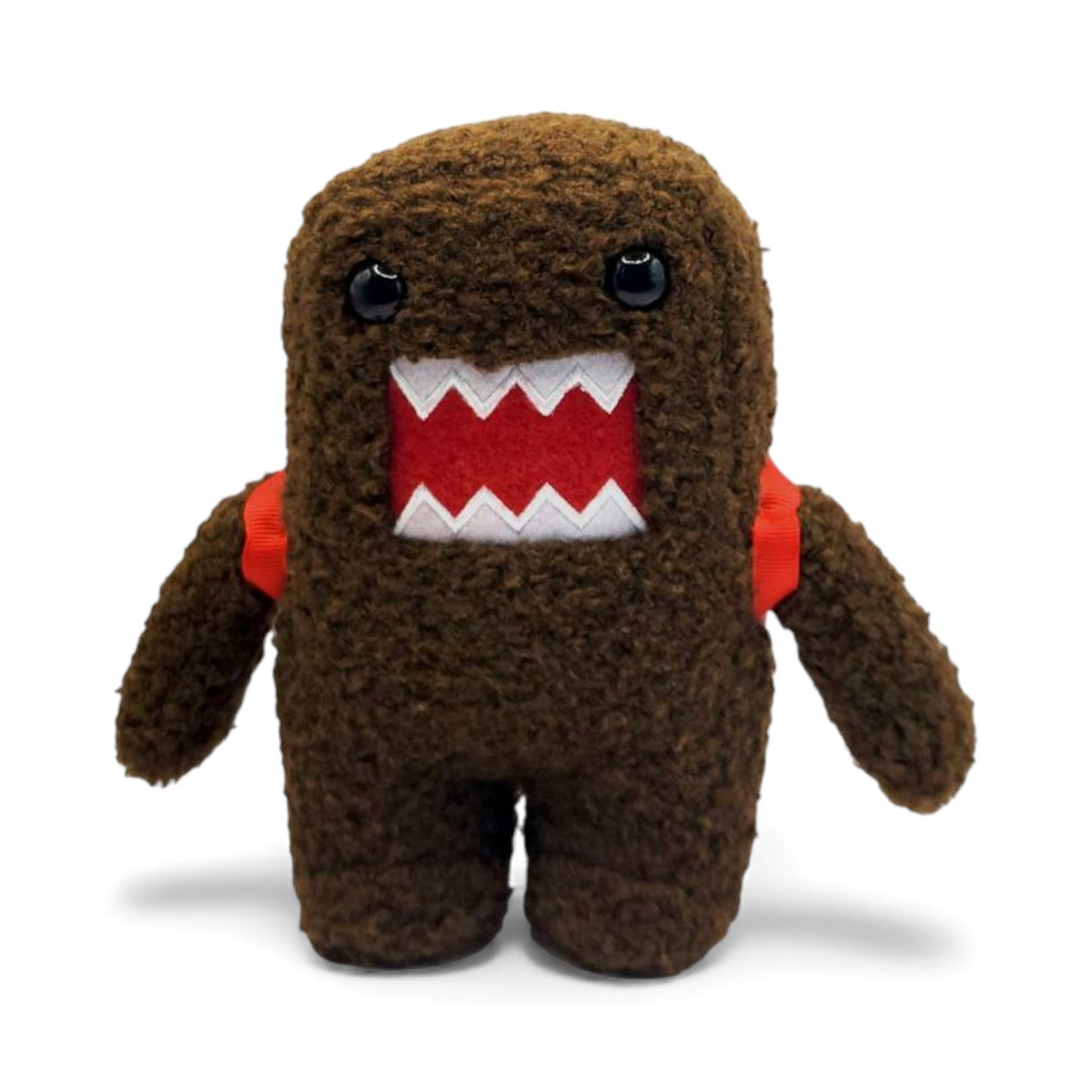 Product view of the 6.5-inch Domo plush, a brown fuzzy monster wearing a red backpack with visible straps on the shoulders.