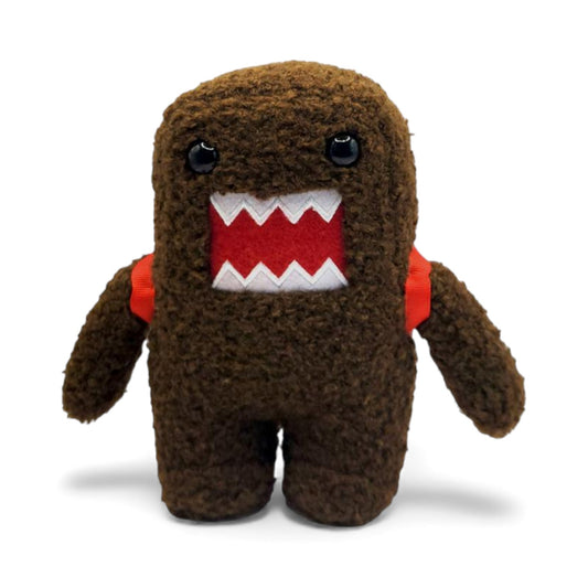 Product view of the 6.5-inch Domo plush, a brown fuzzy monster wearing a red backpack with visible straps on the shoulders.