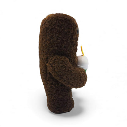 Side view of the 6.5-inch Domo plush, a brown fuzzy rectangular monster with a large open mouth holding a green boba tea cup.