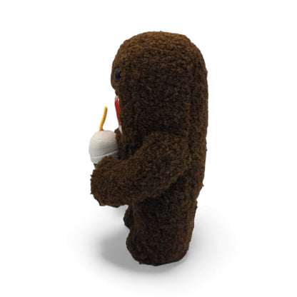 Other side view of the 6.5-inch Domo plush, a brown fuzzy rectangular monster with a large open mouth holding a green boba tea cup.