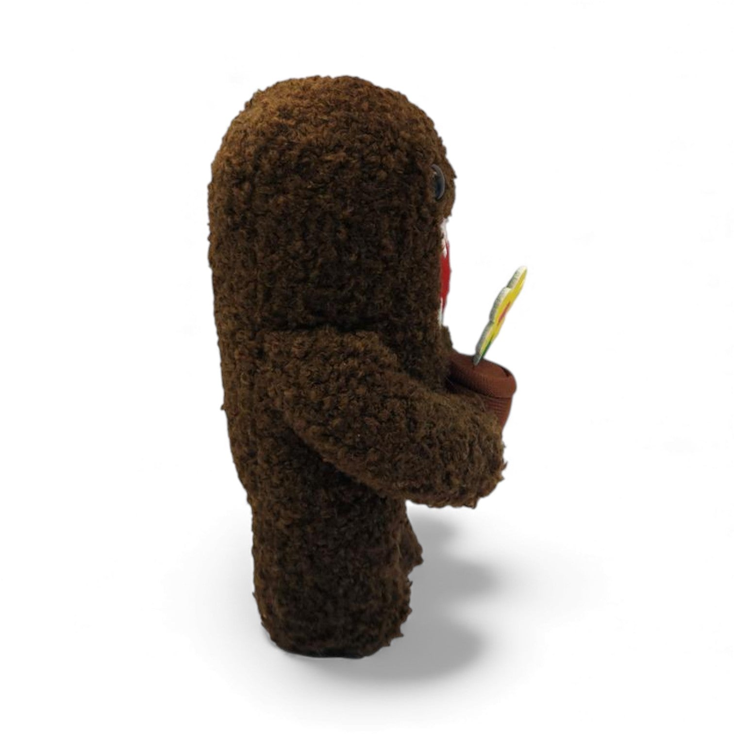 Side view of the 6.5-inch Domo plush, a brown fuzzy monster holding a small
brown pot with a yellow flower.