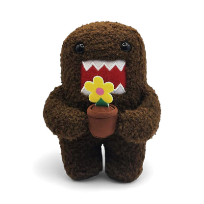 Product view of the 6.5-inch Domo plush, a brown fuzzy monster holding a small brown pot with a yellow flower.