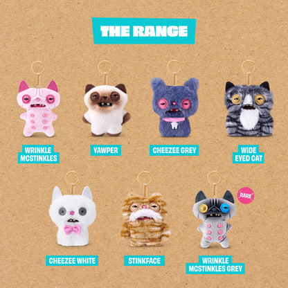 Collection of cat-themed keychains with labels on a brown background