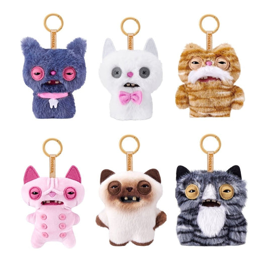 ZURU Fuggler Alley Cats blind box packaging alongside an assortment of plush bag charms featuring human-like teeth.