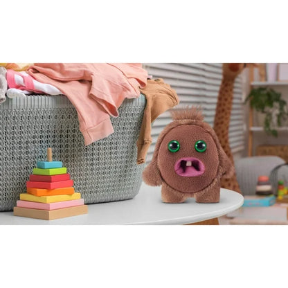 Plush toy resembling a cartoon character on a table with colorful stacking blocks and a basket in the background.