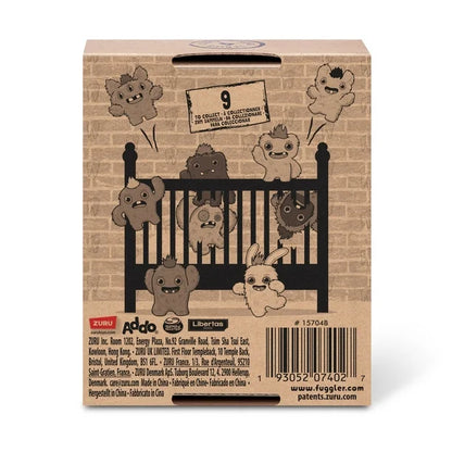 Back of display box for A small, white Fuggler Baby Fugg plush toy (Rabid Rabbit) with long white rabbit ears, large red eyes, one white baby tooth showing in a pink mouth, and a spiky orange tuft of hair on top.