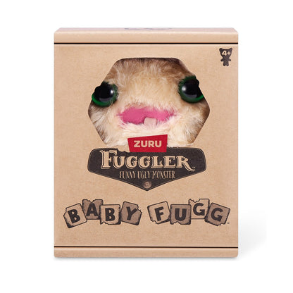 A small, yellowish-beige Fuggler Baby Fugg plush toy (Screech) with large green eyes, one white baby tooth showing in a pink mouth, and a spiky brown tuft of hair on top in display box