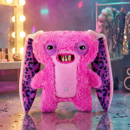 Pink plush toy with leopard print ears on a reflective surface with a blurred background