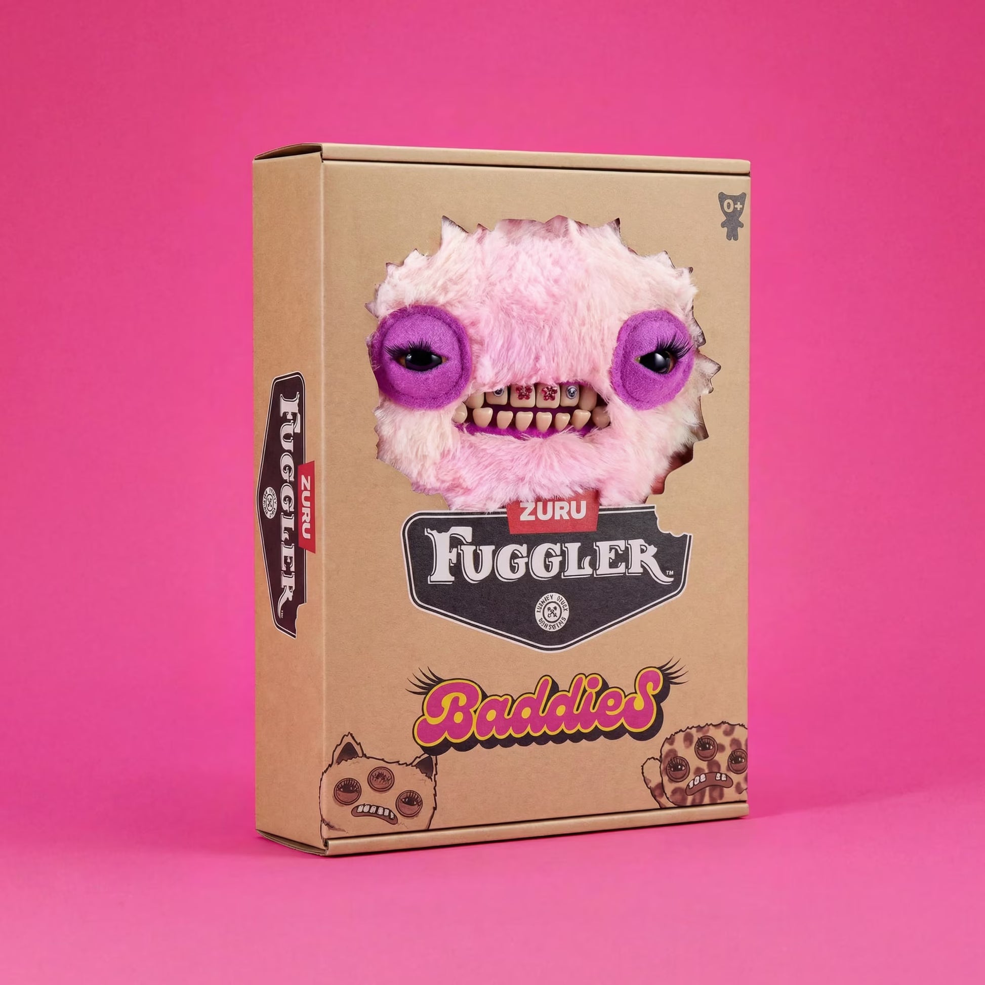 A cardboard product box for ZURU Fuggler, featuring a die-cut window showing a pink fuzzy monster plush with purple eyes and teeth, set against a solid pink background.