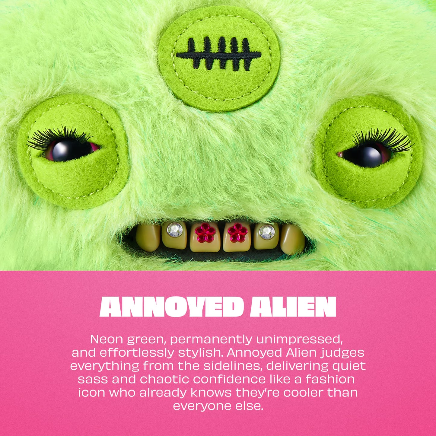 A neon green fuzzy monster face with large embroidered eyes, black eyelashes, a stitched scar patch on the forehead, and a row of teeth with rhinestones and red flower accents. A pink text band at the bottom reads 'ANNOYED ALIEN' with descriptive copy.
