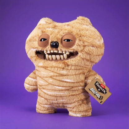 Fuggler Bigg Fugg Chuckles 18-Inch Plush featuring fuzzy tan and white striped fur, a wide mouth with human-like teeth, and heavy-lidded eyes.